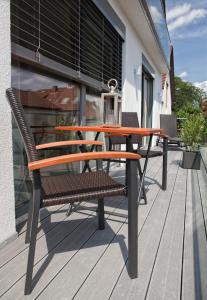 einen Holztisch und einen Stuhl auf einer Terrasse in der Unterkunft Appart-Hotel REB_ART in Deidesheim