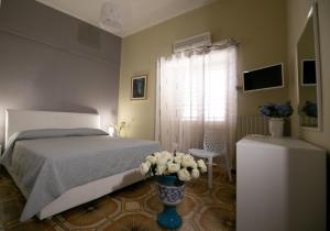 ein Schlafzimmer mit einem Bett und einer Vase aus Blumen in der Unterkunft B&b Al Centro Nicosia in Nicosia
