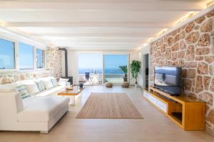 a living room with a white couch and a stone wall at Suite La Mer in Kalkan
