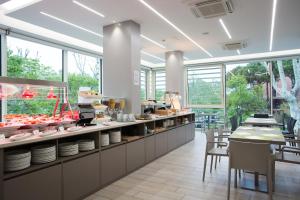 a restaurant with a buffet line with tables and chairs at Hotel Gala in Misano Adriatico