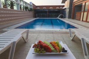 a plate of fruit on a table next to a swimming pool at Queen Palace Hotel in Abu Dhabi +54 photos