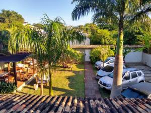 an aerial view of a yard with palm trees and cars at Casarão da Ferradura B&B in Búzios