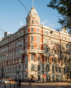un grand bâtiment avec une tour au sommet dans l'établissement Bob W Koti Ullanlinna, à Helsinki