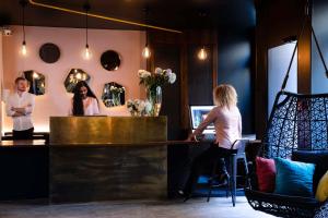 a woman sitting at a bar in front of a computer at Hôtel Maxim Folies in Paris