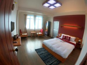 1 dormitorio con 1 cama con pared roja en Aisha Guest House Bed & Breakfast, en Cherrapunji