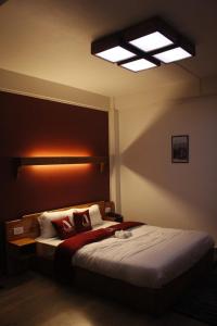 ein Schlafzimmer mit einem Bett mit einer Lampe an der Wand in der Unterkunft Aisha Guest House Bed & Breakfast in Cherrapunji