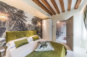ヴェネツィアにあるRialto Luxury Flatのベッドルーム1室(緑のヘッドボード付きの大型ベッド1台付)