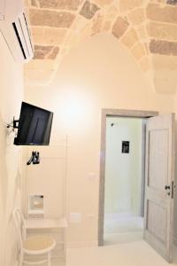 Habitación con TV de pantalla plana en la pared en Dimora Vico dei Nohi, en Lecce