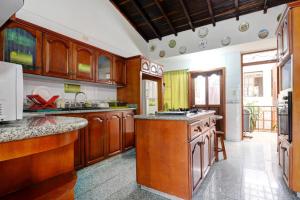 a kitchen with wooden cabinets and a counter top at Sam'S VIP Hostel San Gil in San Gil