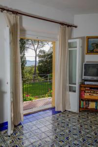 a living room with a sliding glass door with a balcony at Mediterranean Villa in Porto Santo Stefano
