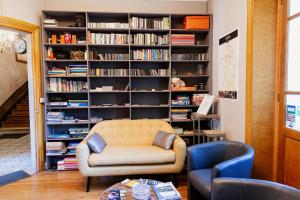 una sala de estar con una estantería llena de libros en Maison d'hôtes La Poterne, en Épernay