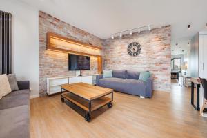 a living room with a couch and a table at Apartamenty Sun & Snow Stara Stocznia in Gdańsk