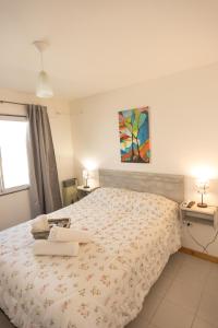 a bedroom with a bed and a painting on the wall at Apartamentos quinta sección in Mendoza