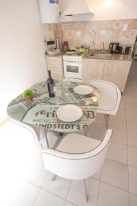 una cucina con tavolo e due sedie bianche di Apartamentos quinta sección a Mendoza