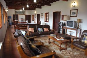uma sala de estar com mobiliário de couro e uma televisão em Hotel Quinta Progresso em Macieira de Cambra