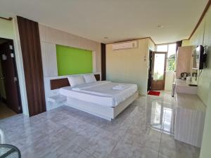 チエンセーンにあるHoney Hotel Chiang Saenの緑の壁、ベッド付きのベッドルーム1室