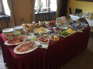 una mesa llena de comida en una mesa roja en Penzion Bene, en Chotěboř