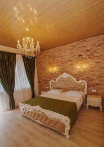 a bedroom with a large bed and a brick wall at Galaktioni's Marani in Kondoli