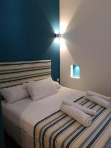 una camera da letto con letto, lenzuola e cuscini bianchi di LOFT 99 a Palermo