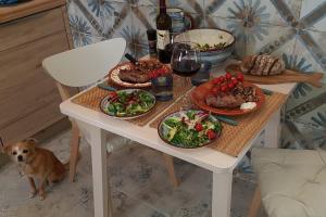 a table with plates of food on it with a dog at Studio Azul in Olhão