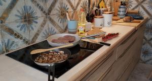 a kitchen counter with a stove with food on it at Studio Azul in Olhão
