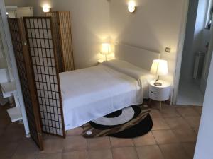a bedroom with a bed and two lamps on a tiled floor at Vicino IFO Intero appartamento in Mostacciano 