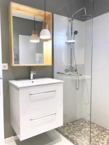 a bathroom with a white sink and a shower at Apartamento Reis Magos in Caniço