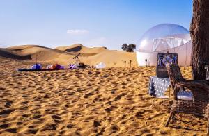 a desert with two chairs and a tent in the sand at STARLIGHT CAMP in Dubai
