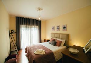 Pedras Salgadas Apartment في بدراس سالغاداس: غرفة نوم عليها سرير وفوط