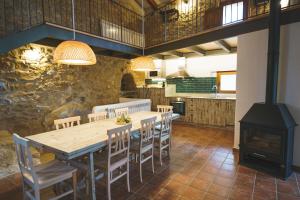 a kitchen with a wooden table and chairs and a stove at Casa rural Mas del Serranet in Horta de San Joan