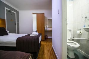 a hotel room with a bed and a toilet at Charing Cross Hotel in Glasgow