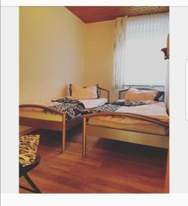 - 2 lits dans une chambre avec fenêtre dans l'établissement Nordseebriese, à Hage