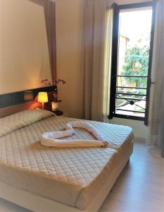 a bedroom with a large bed with a window at HOTEL DOZZA in Dozza