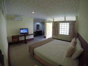 a bedroom with a large bed and a television at OP Bungalow in Chaweng