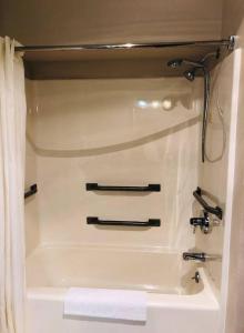 - Baño con bañera blanca y toalla en Boarders Inn & Suites by Cobblestone Hotels - Munising, en Wetmore