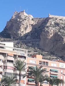 uitzicht op een berg met palmbomen en gebouwen bij pension mexico in Alicante