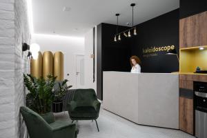 a woman standing at a reception desk in a lobby at Kaleidoscope on Nevskiy in Saint Petersburg