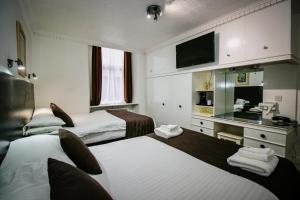 a hotel room with two beds and a television at Charing Cross Hotel in Glasgow