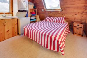 een rood en wit gestreept bed in een kleine kamer bij Seas the Day in Gearhart