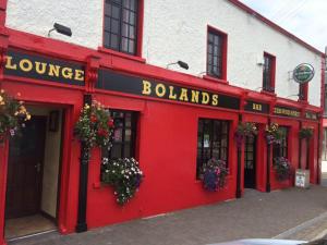 a red facade of a building with flowers on it at Bolands Self Catering Accommodation in Hacketstown