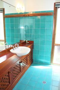 a blue tiled bathroom with a sink and a mirror at AQUA VIEW in Boomerang Beach