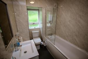 a bathroom with a tub, toilet and sink at Charing Cross Hotel in Glasgow