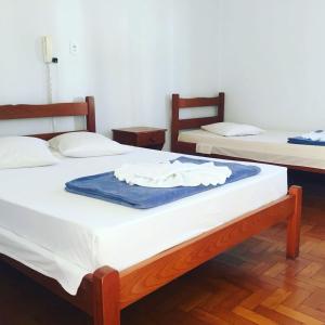 2 łóżka w pokoju z trybem zapalenia płci w obiekcie Hotel Guanabara w mieście Caraguatatuba