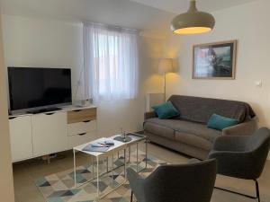 ein Wohnzimmer mit Sofa und Fernseher in der Unterkunft LE CLOS SAINTE MARIE in Pornic