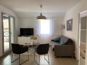 ein Wohnzimmer mit Sofa, Tisch und Stühlen in der Unterkunft LE CLOS SAINTE MARIE in Pornic + 4 Fotos