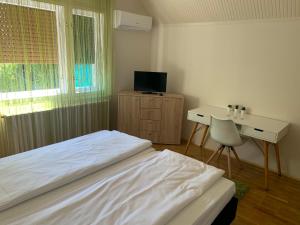 サルバシュにあるCsuka48 Apartmanのベッドルーム(ベッド1台、デスク、テレビ付)