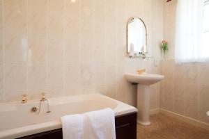 a bathroom with a sink and a tub and a sink at The Tomich Hotel in Tomich