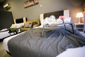 ein Schlafzimmer mit einem Bett mit Ballons und einem Sofa in der Unterkunft Palazio Apartment Mount Austin By The one in Johor Bahru
