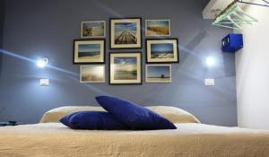 a bedroom with a blue wall with pictures on it at Casa Mazzone in Cirò