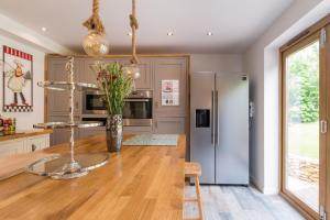 uma cozinha com uma mesa e um frigorífico em The Hidden House em Stroud